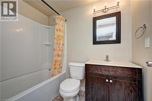 Full bathroom featuring a corner vanity with a wood-finish base, white countertop, and single-handle faucet - 760 Paris Boulevard, Waterloo, ON 