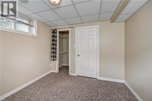Carpeted room featuring a drop ceiling, white trim, and neutral wall tones - 760 Paris Boulevard, Waterloo, ON 