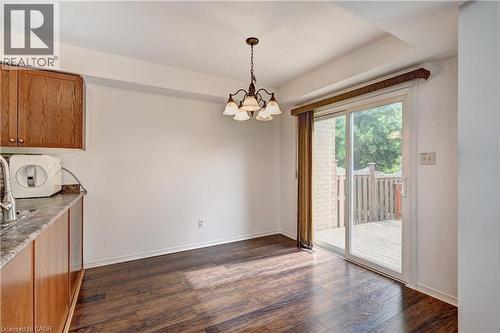 Dining area featuring wood-finish flooring, a contemporary chandelier, and direct access to an outdoor deck via a sliding glass door - 760 Paris Boulevard, Waterloo, ON 