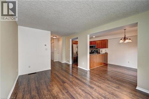 Wood-finish flooring throughout, featuring a kitchen with wood cabinetry, stainless steel appliances, and a built-in microwave - 760 Paris Boulevard, Waterloo, ON 