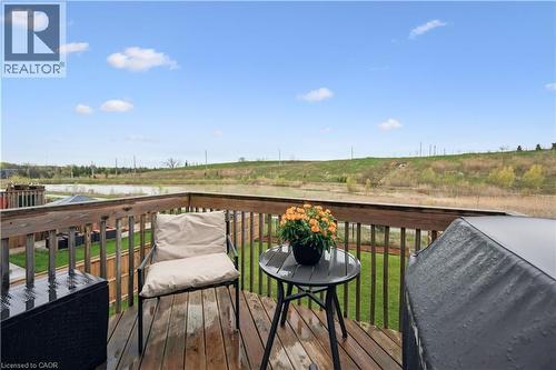 Wood-finish deck with wooden railings overlooking a body of water and expansive green space - 87 Ridge Road, Cambridge, ON 