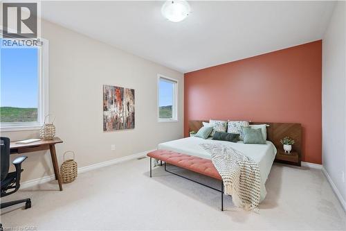 Spacious room featuring a vibrant accent wall, light carpeting, and two large windows - 87 Ridge Road, Cambridge, ON 