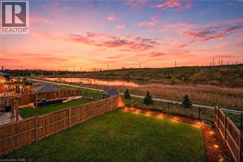 Expansive backyard featuring a manicured lawn, wood fencing, and perimeter lighting - 87 Ridge Road, Cambridge, ON 