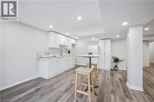 Kitchenette featuring white cabinetry, a sink, and a white refrigerator - 87 Ridge Road, Cambridge, ON 