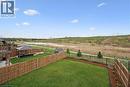 Expansive green lawn framed by a wooden fence, featuring a paved patio area, a gazebo, and a storage shed - 87 Ridge Road, Cambridge, ON 
