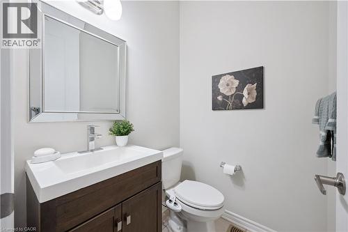 Modern vanity with dark wood-finish cabinetry, integrated white sink, and chrome faucet - 87 Ridge Road, Cambridge, ON 