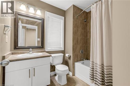 Bathroom featuring a built-in vanity with a countertop and undermount sink, a framed wall mirror, and a combination tub and shower with tile surround - 8 Hemlock Way Unit# 22, Grimsby, ON 