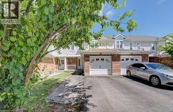 Brick and siding exterior featuring white garage doors and a double window dormer - 
