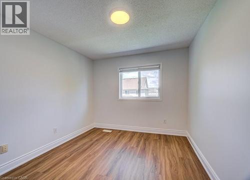 Bright room featuring light-toned walls, wood-finish flooring, and white baseboards - 139 Werstine Terrace, Cambridge, ON 
