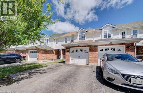 Exterior featuring brick and siding construction, dormer windows, attached garage, paved driveway, and mature tree - 139 Werstine Terrace, Cambridge, ON 