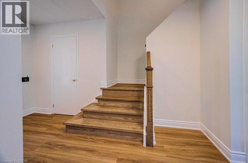 Wood-finish flooring throughout, featuring a staircase with wood treads and a decorative newel post - 139 Werstine Terrace, Cambridge, ON 