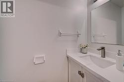 Vanity featuring a white countertop, undermount sink, and matte gray faucet - 