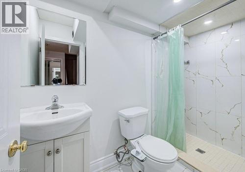 Bathroom featuring a white vanity with integrated sink, chrome faucet, wall-mounted mirror, and recessed lighting - 139 Werstine Terrace, Cambridge, ON 