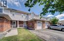 Brick and siding exterior featuring white garage doors, a covered front porch with white railing, and a paved driveway - 139 Werstine Terrace, Cambridge, ON 