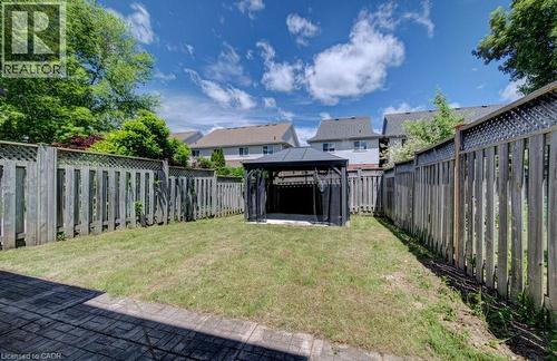 Fenced backyard featuring a lawn area, a black gazebo, and a stone patio - 139 Werstine Terrace, Cambridge, ON 