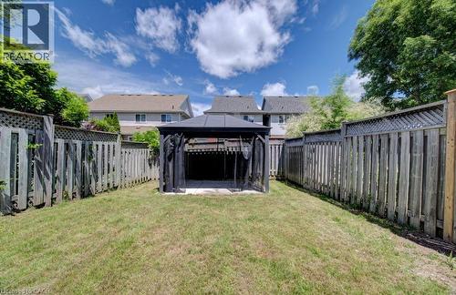 Expansive fenced backyard featuring a central gazebo with dark fabric screens - 139 Werstine Terrace, Cambridge, ON 