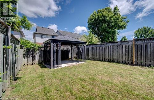 Expansive grassy yard featuring a paved patio area, a dark-framed gazebo structure, and full perimeter fencing - 139 Werstine Terrace, Cambridge, ON 