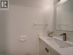 Bathroom vanity featuring a rectangular undermount sink, a light-colored countertop, and a brushed nickel faucet - 