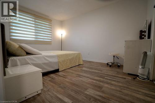 Spacious room featuring wood-finish flooring, white walls, and a large window with horizontal blinds - 147 Muriel Crescent, London, ON 