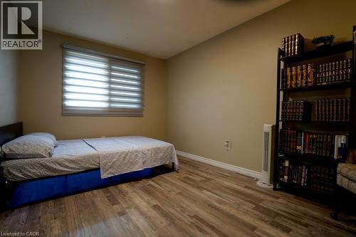 Room featuring wood-finish flooring, a window with horizontal blinds, and baseboard trim - 147 Muriel Crescent, London, ON 