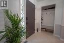 Entryway featuring a dark paneled door with decorative glass inserts, ceramic tile flooring, and a built-in mudroom area with shelving, hooks, and bench seating - 147 Muriel Crescent, London, ON 
