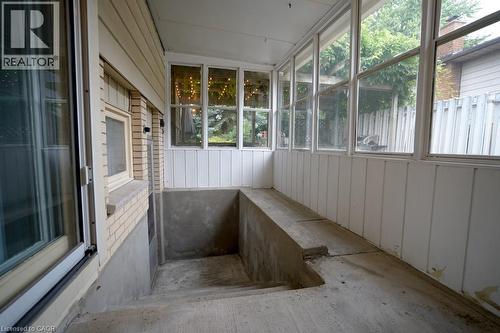 Screened-in porch featuring a concrete floor, concrete bench seating, and clear glass windows - 147 Muriel Crescent, London, ON 
