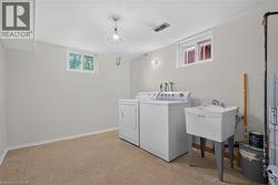Laundry area featuring a utility sink, a washer, and a dryer - 