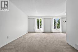 Spacious Living Room featuring light-colored carpeting, white walls, and bright white trim - 