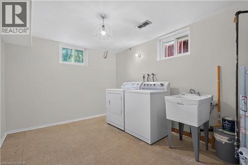 Laundry area featuring a utility sink, a washer, and a dryer - 5051 Brady Avenue, Burlington, ON - Indoor Photo Showing Laundry Room