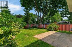 Spacious fully-fenced backyard featuring patio and mature trees - 