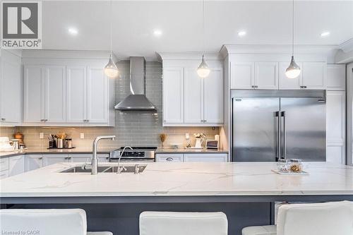 Kitchen featuring a large island with an undermount sink, white shaker cabinetry, stainless steel appliances, a tile backsplash, and recessed and pendant lighting - 47 Hawke Crescent, New Tecumseth, ON 