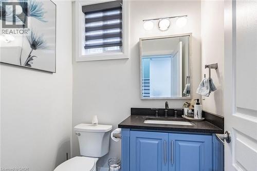 Powder room featuring a blue vanity with dark countertop, undermount sink, and dark-finish faucet - 47 Hawke Crescent, New Tecumseth, ON 