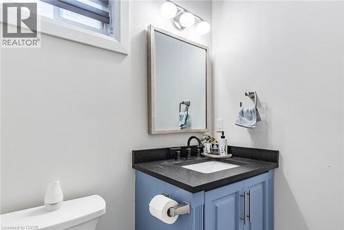 Bathroom vanity with blue cabinetry, a dark countertop, and an undermount sink - 47 Hawke Crescent, New Tecumseth, ON 
