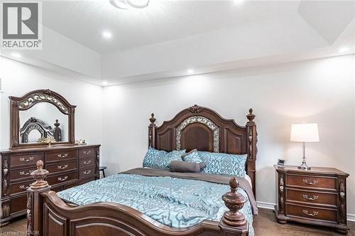 Bedroom featuring a tray ceiling with recessed lighting, wood-finish flooring, and white wall finishes - 47 Hawke Crescent, New Tecumseth, ON 