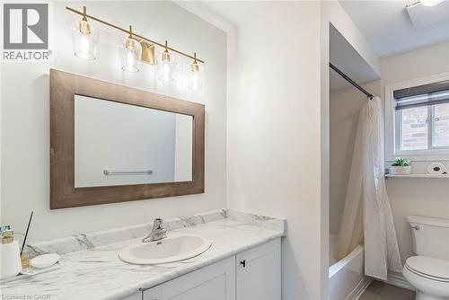 Bathroom featuring a single vanity with an oval sink, a framed mirror, and a four-light vanity fixture - 47 Hawke Crescent, New Tecumseth, ON 