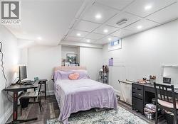 Recessed lighting illuminates this room, featuring wood-finish flooring and a dropped panel ceiling - 