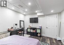 Spacious room featuring wood-finish flooring, recessed lighting, and a paneled ceiling - 