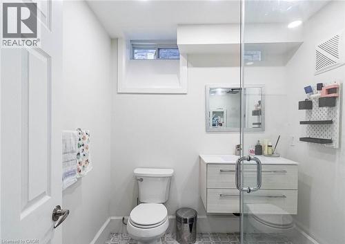 Modern bathroom featuring a glass-enclosed shower, floating vanity with two drawers, wall-mounted mirror, and a white toilet - 47 Hawke Crescent, New Tecumseth, ON 