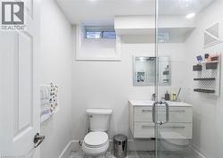 Modern bathroom featuring a glass-enclosed shower, floating vanity with two drawers, wall-mounted mirror, and a white toilet - 