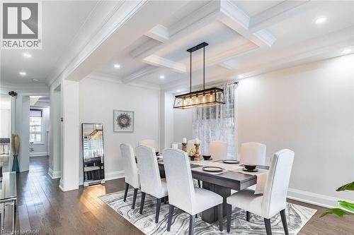 Dining area featuring wood-finish flooring, coffered ceiling with recessed lighting, crown molding, and a contemporary linear chandelier - 47 Hawke Crescent, New Tecumseth, ON 