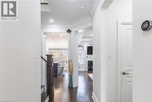 Hallway featuring wood-finish flooring, white paneled doors, recessed lighting, and crown molding - 47 Hawke Crescent, New Tecumseth, ON 