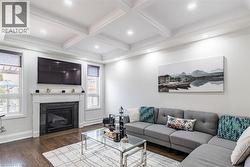 Living area featuring dark wood-finish flooring and a coffered ceiling with recessed lighting - 