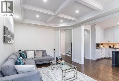 Living area featuring a coffered ceiling with recessed lighting, dark wood-finish flooring, and bright white walls - 47 Hawke Crescent, New Tecumseth, ON 