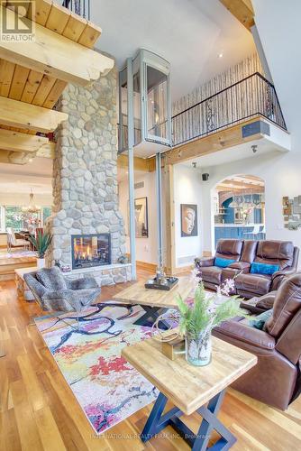 Commanding double-sided stone gas fireplace. - 6 Pinehurst Lane, Springwater, ON - Indoor With Fireplace