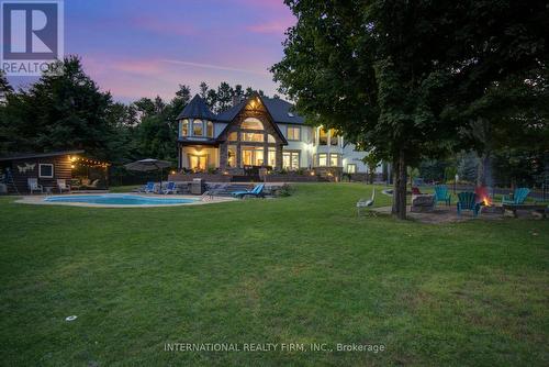 Spectacular resort-style pool & fire-pit at night. - 6 Pinehurst Lane, Springwater, ON - Outdoor With Backyard