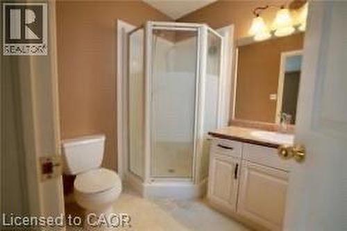 Bathroom featuring a corner glass shower enclosure, single vanity with a light-toned countertop, and a built-in mirror - 17 Hawkswood Drive, Kitchener, ON 