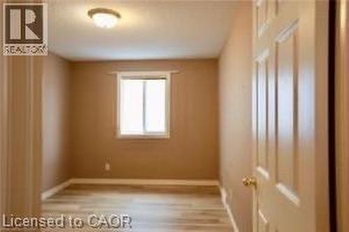 Room featuring wood-finish flooring, neutral wall paint, and a window with natural light - 17 Hawkswood Drive, Kitchener, ON 