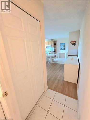 Entryway featuring paneled bifold doors, neutral-toned tile flooring, and wood-finish flooring extending into the interior space - 2373 E King Street E Unit# 37, Hamilton, ON 