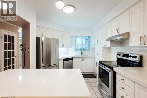 Bright kitchen featuring white cabinetry, stainless steel appliances, a white countertop, and tile flooring - 171 Mcnichol Drive, Cambridge, ON 