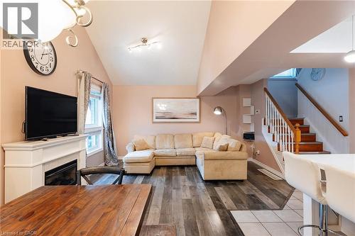 Open-concept living area featuring high vaulted ceilings, wood-finish flooring, and a white mantel fireplace - 171 Mcnichol Drive, Cambridge, ON 